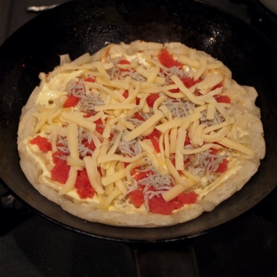 弱火に落とし、お餅の表面にマヨネーズをスプーンの背などで塗り広げ、明太子・しらす・チーズをのせたら溶けるまで蓋をして焼きます。