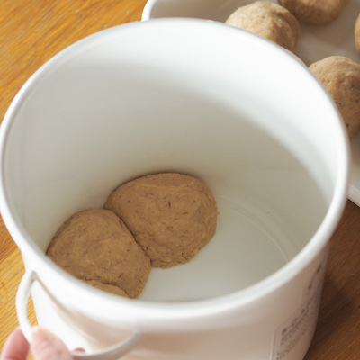容器の中に空気が残らないように丸めた味噌玉を投げつけるように入れます。空気が入るとカビの原因に。隙間なく詰めてください!