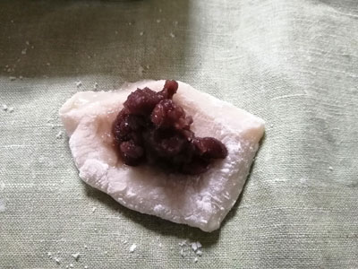 平らに伸ばしてあんこをのせて包み、丸く整える