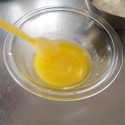 耐熱ボウルにバターを入れ、電子レンジで1分加熱して溶かし、そこに砂糖を加えて混ぜる。(砂糖が溶けきらなくてもOK)