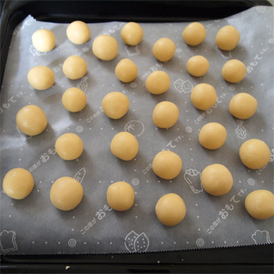 まとめた生地を20等分にして、手のひらでクルクルと丸め、オーブンペーパーを敷いた天板に並べる。