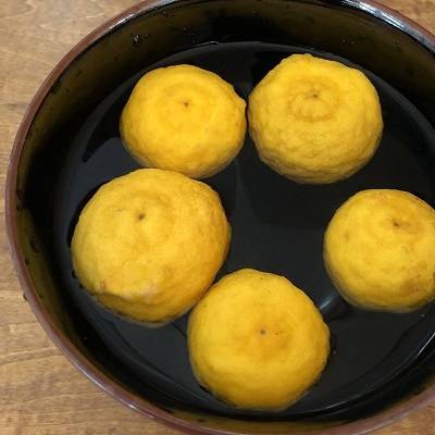 柚子を洗って酢を入れた水に1時間ほどつけておきます。流水で洗って水けをよくふき取ったら、皮をむきます。皮の表面にナイフで薄く線を入れると向きやすいです。