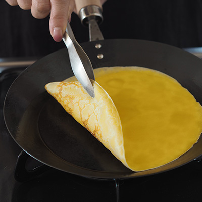 生地の縁がうすく色づき、少し浮いてきたら、トングやヘラを差し入れて手で持ち上げて返します。写真はコンテのおてがる薬味トング。ほどよく先が細く差し込みやすい!