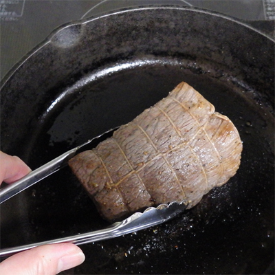 スキレットで肉の表面を焼き固めたらそのまま弱火にしてアルミホイルを被せて「簡易オーブン」にします