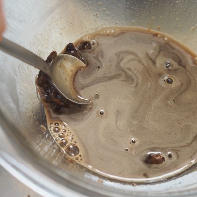 一度取り出し、計量スプーンなどの背で黒糖をつぶしながら溶かし、残りの牛乳50ccを入れてさらに20秒ほど温めて黒糖を溶かす。