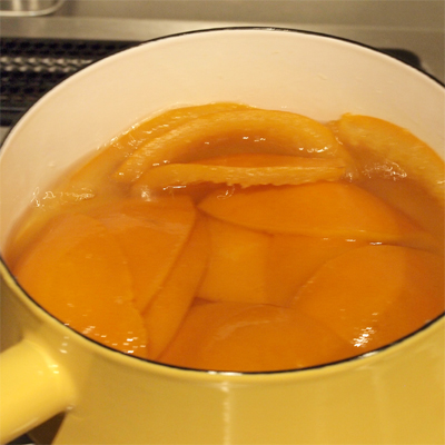 鍋にグラニュー糖とひたひたの水を入れて火にかけ、沸騰したら弱火で30分程煮る。皮とわたが透明でつやっとしていたらOKです。ワタは苦みのもとですが、ついたままのほうが厚く出来て私は美味しいと思います。