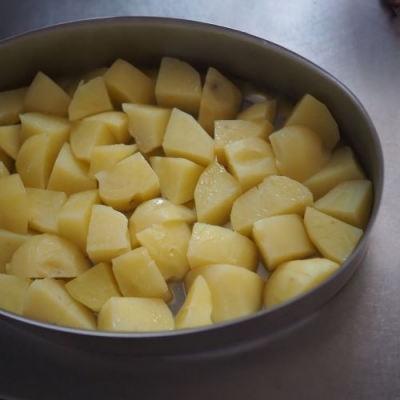 一口大に切ったジャガイモを耐熱容器に入れて電子レンジ600Wで約6分加熱する。串をさして中まで刺せればOK。オーブンディッシュに敷き詰める