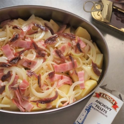 薄切りにした玉ねぎと切ったベーコンを軽く炒めたら、ジャガイモの上に載せる。アンチョビをちぎって全体に散らす。