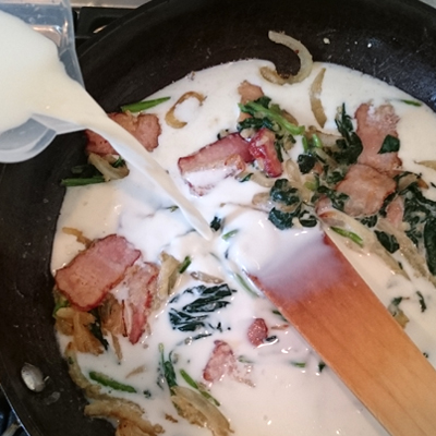 そこに牛乳を入れてかきまぜてから、中火でとろみがつくまで煮て、コンソメを入れる。