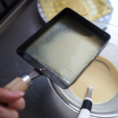 玉子焼き器を中火で熱し最初だけ油を薄くひいて、生地を入れて玉子焼き器をまわして薄く広げる。2枚目からは油をひかなくてもOKですが、火からおろして生地を入れてください。