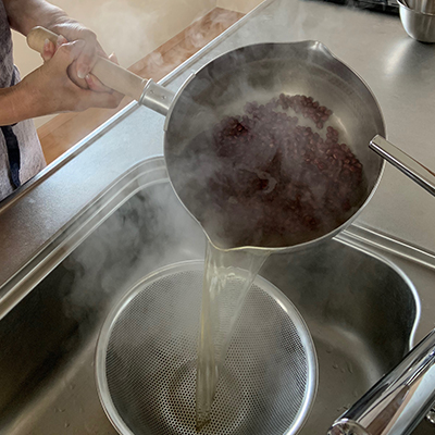 小豆をざるにあげて水気を切り、流水で軽く洗って水気を切ります。