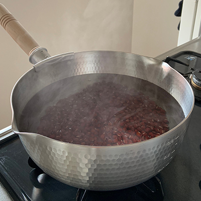 再び小豆を鍋に戻し入れ、水を加えて火にかけます。小豆の頭が出てきたら水を足していきましょう。