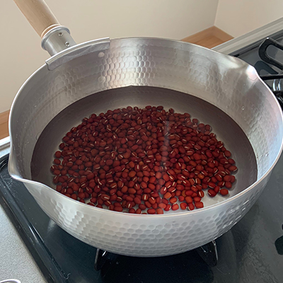 小豆をボウルににうつしてひと洗いしてから鍋に入れて、たっぷりの水を加え火にかけます。沸騰してから3分ほど茹でます。