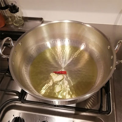 鍋にオリーブオイルを入れ、潰したにんにくと赤唐辛子を入れて火をつけ、香りを出す。